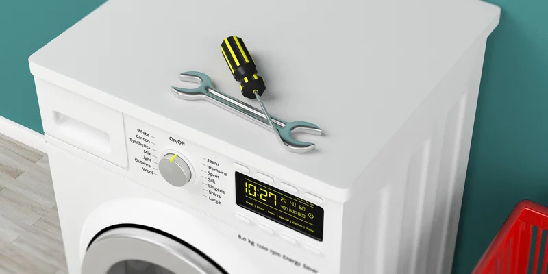 Tools resting on a white washing machine for repair service