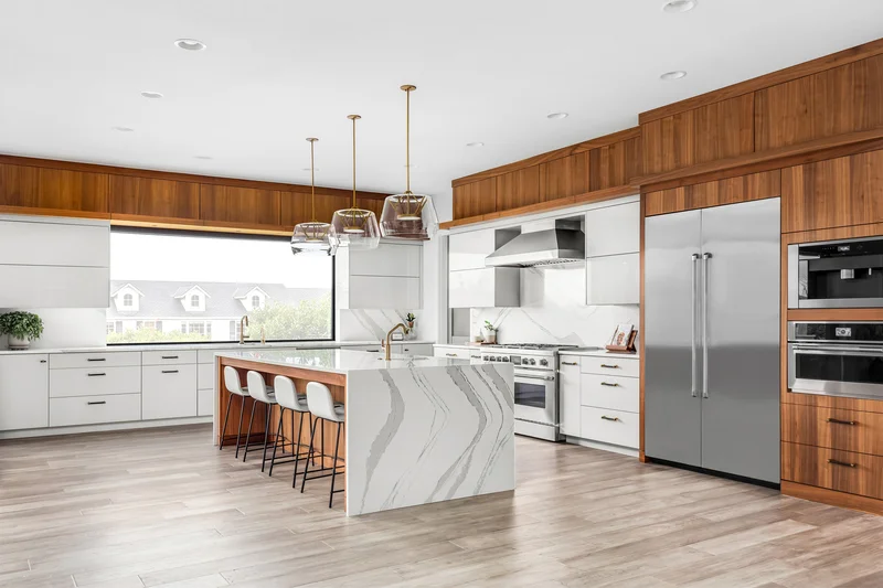 Luxury kitchen with stainless steel refrigerator, white cabinets, and large island. Luxury kitchen with stainless steel refrigerator, white cabinets, and large island.