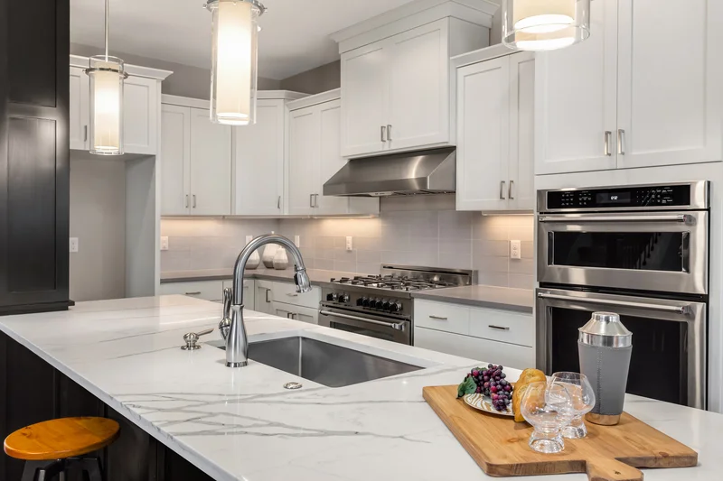 Luxury kitchen interior featuring a marble island and stainless steel double wall oven Luxury kitchen interior featuring a marble island and stainless steel double wall oven