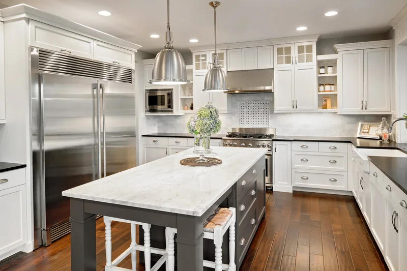Luxury kitchen with stainless steel refrigerator and large island.