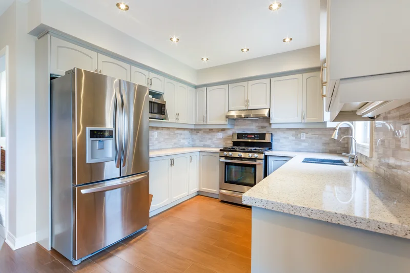 Modern kitchen interior featuring stainless steel refrigerator and gas stove