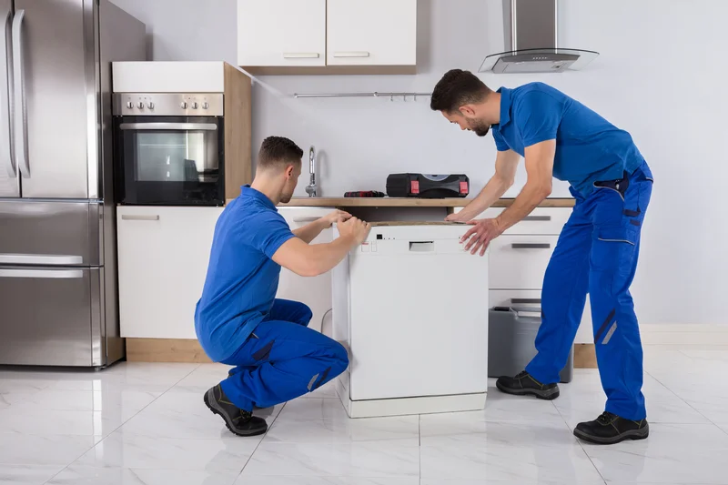 Two technicians installing or repairing kitchen dishwasher