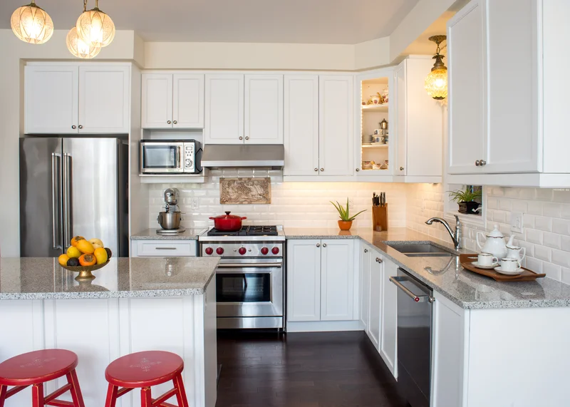 Modern white kitchen featuring stainless steel major appliances.